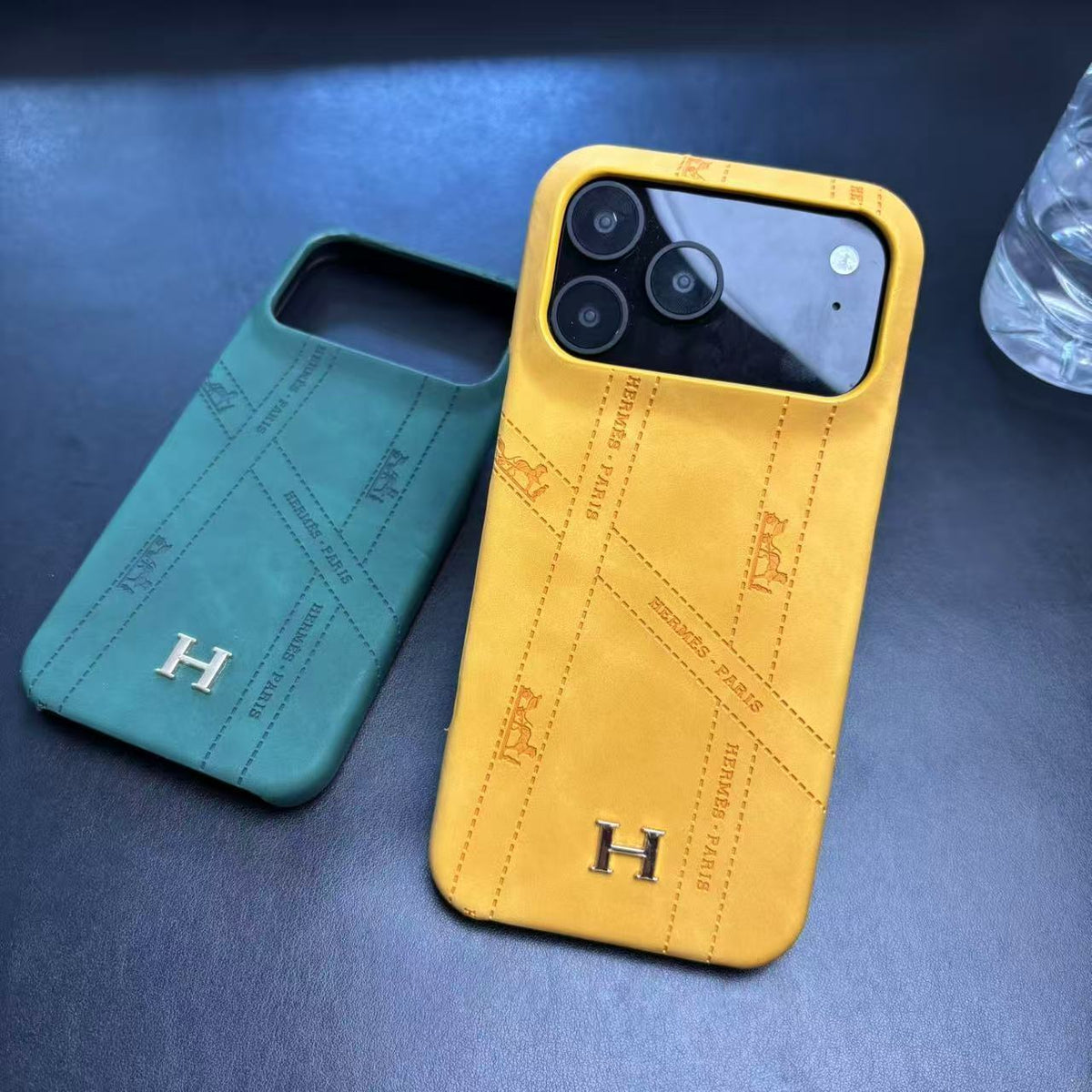 Hermes-inspired solid color iPhone 17 case with metal initial detail