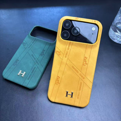 Hermes-inspired solid color iPhone 17 case with metal initial detail