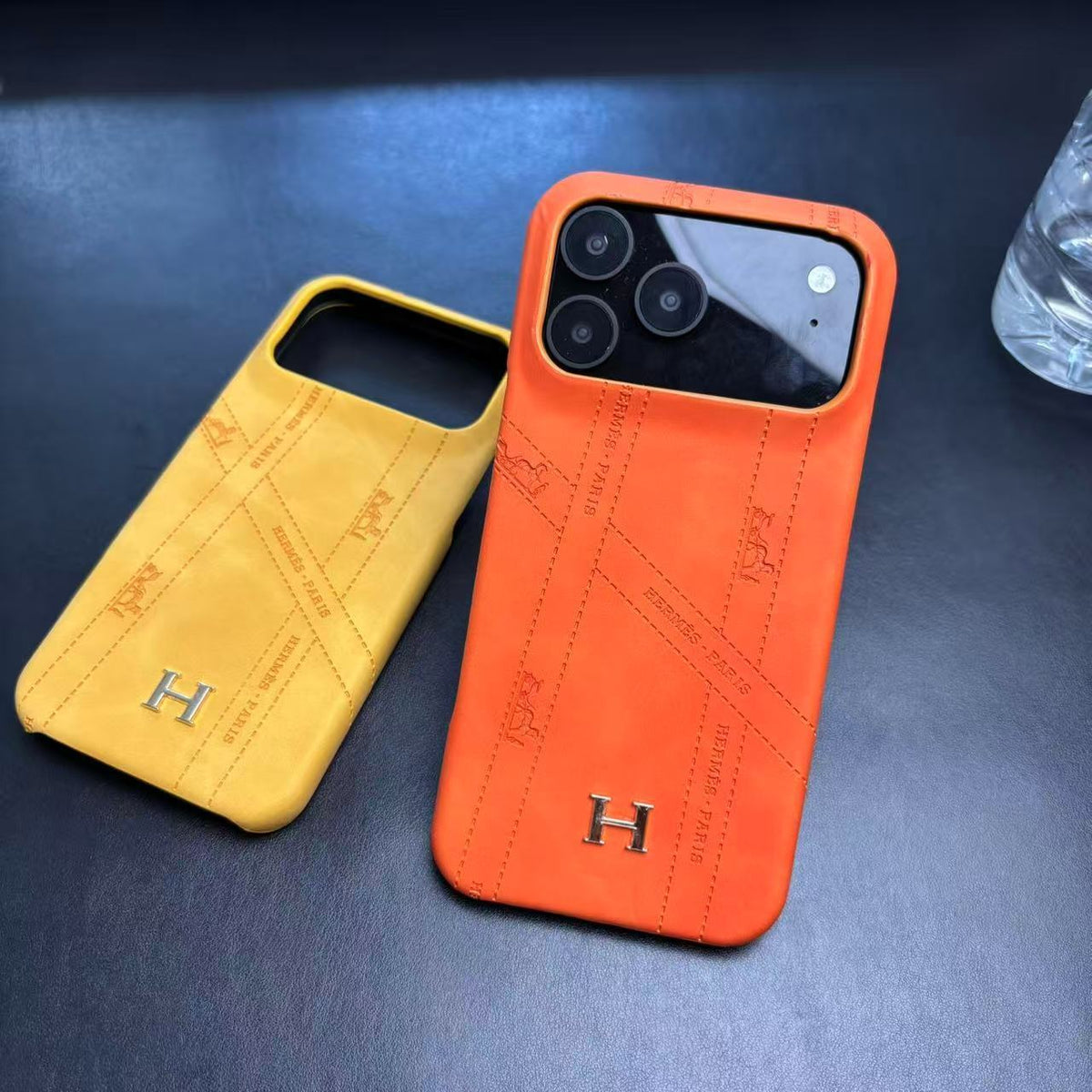 Hermes-inspired solid color iPhone 17 case with metal initial detail
