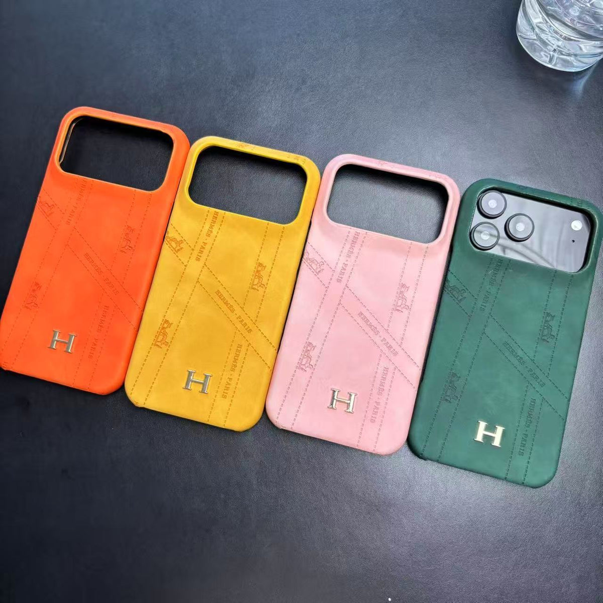 Hermes-inspired solid color iPhone 17 case with metal initial detail