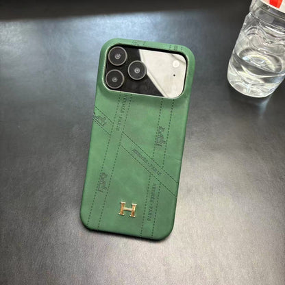 Hermes-inspired solid color iPhone 17 case with metal initial detail