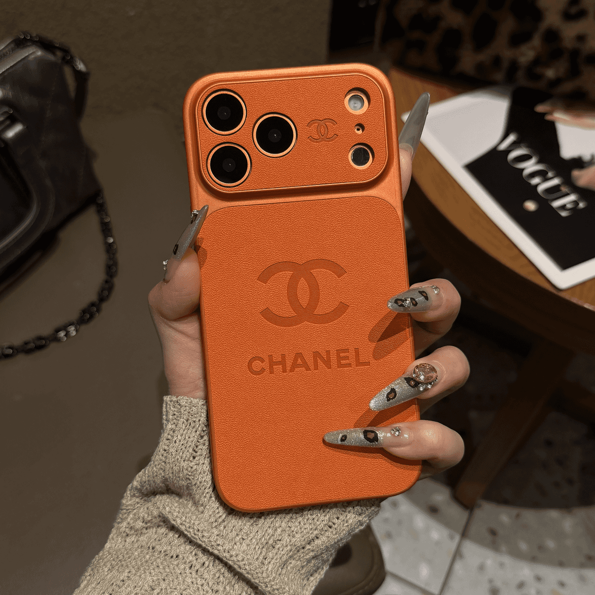 Chanel-inspired solid color iPhone case with embossed emblem, orange